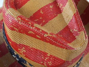 Macro shot of retro woven straw cowboy hat featuring American flag pattern texture