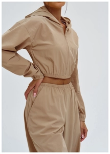 Detail view of khaki hooded sports jacket with zip-up design and slim fit waist hem