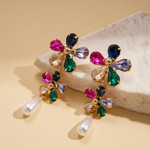 Detailed close-up of 18k gold plated flower earrings with crystals and pearl drops