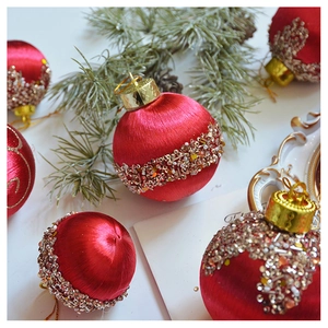 Detailansicht der roten Satin-Weihnachtskugel mit funkelndem Pailletten- und Perlenband
