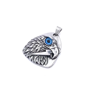Détail du pendentif médiator en argent avec tête d'aigle sculptée et pierre bleue