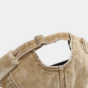 Detail of khaki corduroy docker hat with adjustable metal buckle and ribbed texture
