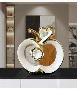 Detail of ceramic apple decor with white flower relief and golden plated edges