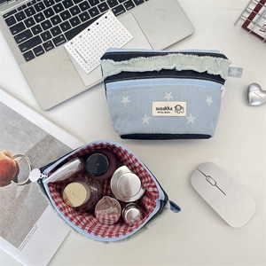 Detail der Patchwork-Jeans-Kosmetiktasche mit weißen Sternen und rot-weißem Futter