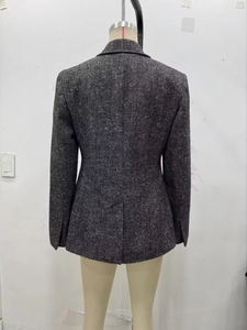 Dettaglio del taglio posteriore di un blazer grigio a spina di pesce con fondo a gonna