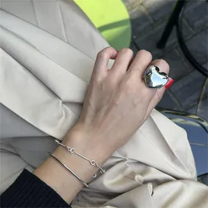 Close-up of a 925 silver large heart ring, minimalist bangle and chain bracelet set