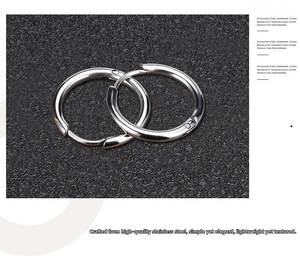 Detailed view of polished silver stainless steel hoop earrings on black texture