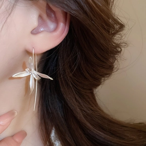 Detail shot of silver flower orchid earrings with long graceful chain on model