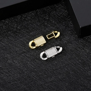 Gold and silver cubic zirconia encrusted Cuban link chain clasps on black background