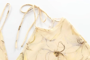 Détail du lien licou fleuri et de la texture du tissu sur la robe longue fendue
