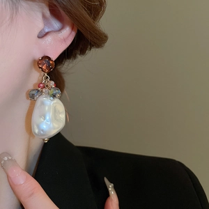 Close-up of baroque irregular pearl earring with brown crystal and vintage gold finish