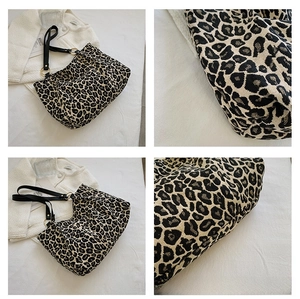 Detailed views of leopard print canvas tote bag with black strap and golden ring hardware