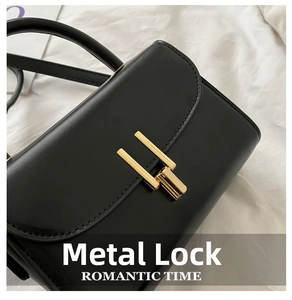 Close-up of golden hardware lock on black leather handbag with romantic metal detail