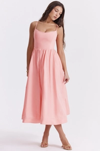 Detail of elegant pink summer dress featuring thin straps and backless design