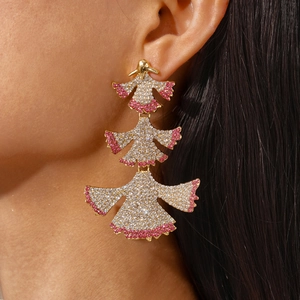 Detailed close-up of large three-layer gold fan-shaped earrings with pink and white rhinestones