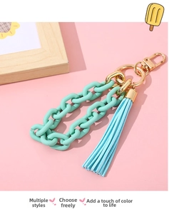 Detail of mint green frosted chain and suede tassel with golden lobster clasp for bag