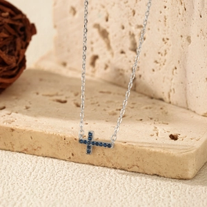 Luxurious S925 sterling silver cross necklace with pavé blue diamonds on stone base