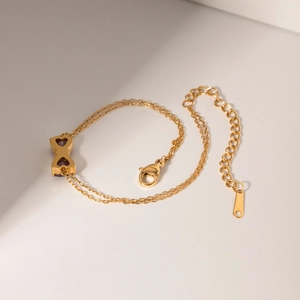 Detail of 18k gold plated stainless steel bracelet with purple zircon heart charms
