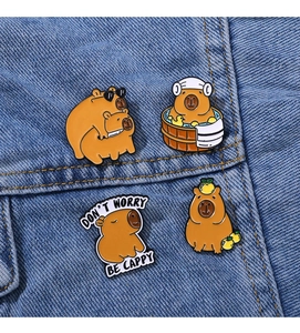 Détail de quatre épingles en émail Capybara sur denim, designs d'animaux mignons pour sacs