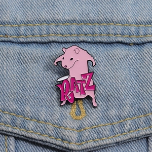 Cute pink cartoon RATZ enamel pin featuring a Rufus character on a blue denim jacket pocket