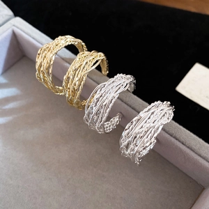 Macro shot of gold and silver crossover rings featuring a twisted metal texture finish
