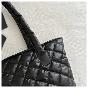 Détail du sac cabas matelassé noir montrant la texture en nylon et les coutures carrées
