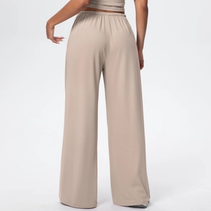 Back view of beige wide-leg drawstring pants with elastic high waist and soft drape