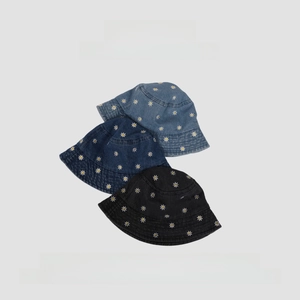 Detail of denim bucket hats with white daisy embroidery in light blue, dark blue and black