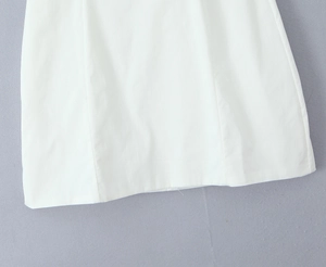 Detail des weißen Bodycon-Kleidsaums aus hochwertigem, glatt gewebtem Textilstoff
