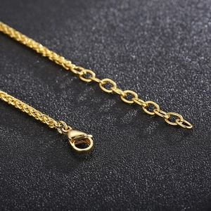 Detailed close-up of golden metal necklace chain with lobster clasp and extension