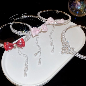 Detail of elegant pearl necklaces featuring crystal bows and long flowing tassels