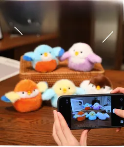 Photo créative de breloques d'oiseaux en peluche colorées sur une table en bois