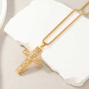 Macro detail of the golden cross pendant featuring a hollow tree pattern on stone base