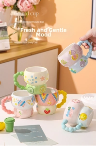 Detail of hand-painted embossed gourd ceramic cup with strawberry and floral patterns
