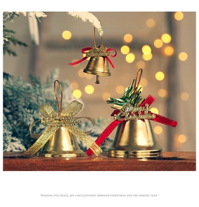 Close-up of golden Christmas bells with red bows and Merry Christmas lettering