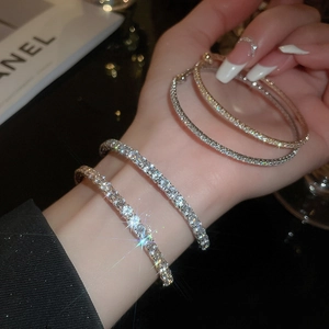 Detail of four silver-plated bangle bracelets featuring micro-pave sparkling crystals