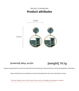 Vue détaillée de boucles d'oreilles géométriques avec incrustations acryliques marbrées