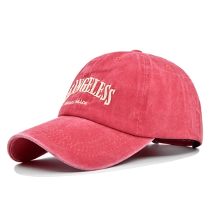 Close-up of white LOS ANGELESS embroidery on a vintage red washed cotton baseball cap