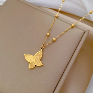 Collier minimaliste avec pendentif papillon doré et chaîne perlée sur boîte à bijoux