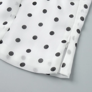 Detailed macro view of high-quality white polka dot fabric and a hidden zipper closure