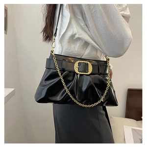 Détail du sac bandoulière plissé noir brillant avec chaîne dorée et boucle métal gravée