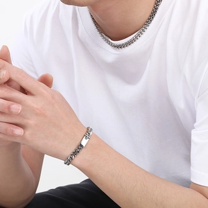 Polished silver cuban link necklace and bracelet set worn by a model on white tshirt
