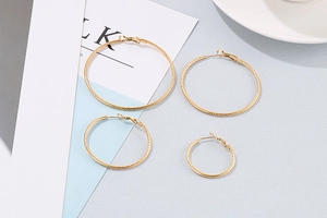 Detail view of four pairs of golden twisted rope hoop earrings in varying sizes