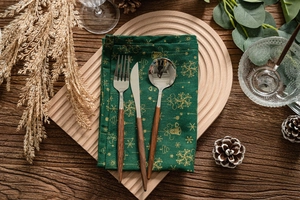 Détail macro d'un ensemble de couverts à manche en bois sur nappe de Noël