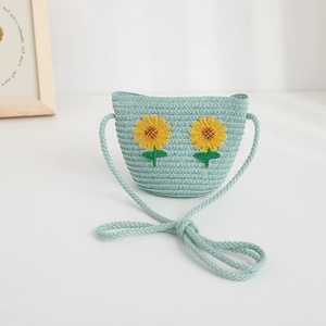 Dettaglio della borsa a tracolla intrecciata verde menta chiaro con ricamo di girasole