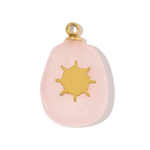 Close-up of a pink oval resin pendant with a golden sunburst star charm and metal ring