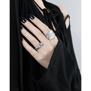 Italian style brushed silver clover ring and three-diamond band worn on finger