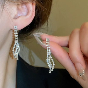 Detailed close-up of sparkling silver leaf tassel earrings with rhinestone tassels