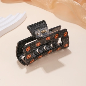 Halloween black hair claw clip with orange pumpkin smiles and shimmering finish