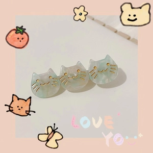 Detail shot of three cute cat-shaped hair clips with green marble texture and gold accents